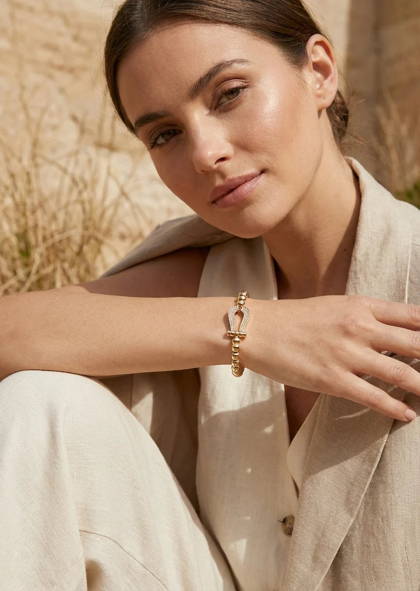 Gold bead stretch bracelet with a cristal horseshoe